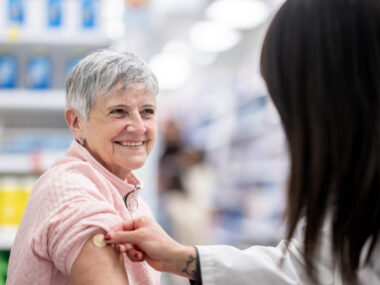 A woman receives a vaccine in a pharmacy.