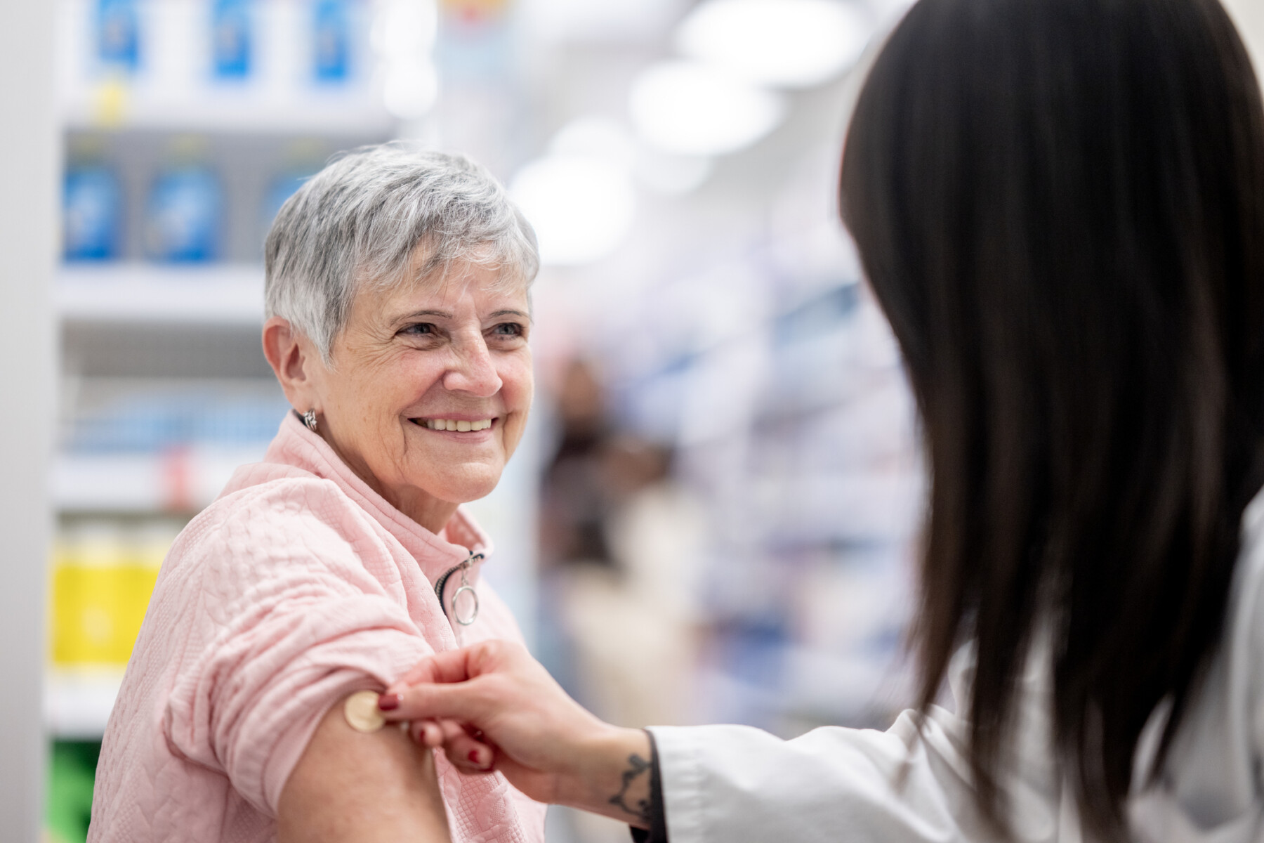 A woman receives a vaccine in a pharmacy.