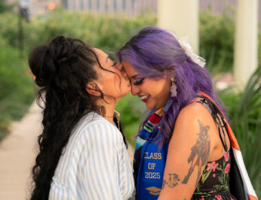 A woman kisses a young woman on her forehead.