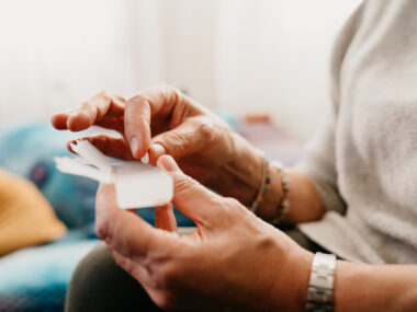A person is shown holding her pill organizer.