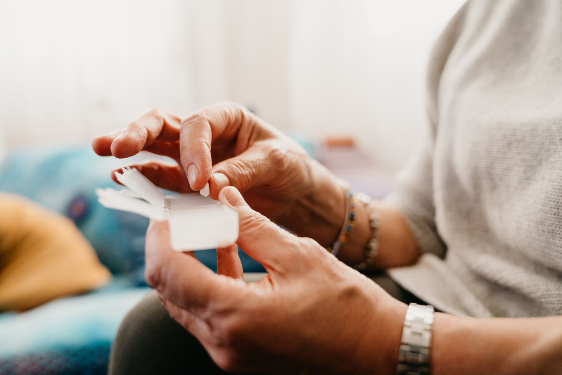 A person is shown holding her pill organizer.