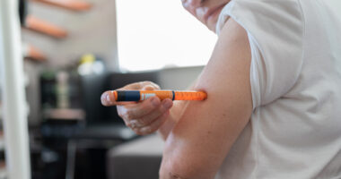 An image of a person preparing to self-inject medication at home.
