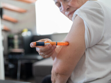 An image of a person preparing to self-inject medication at home.