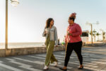 Two people walk on a boardwalk.