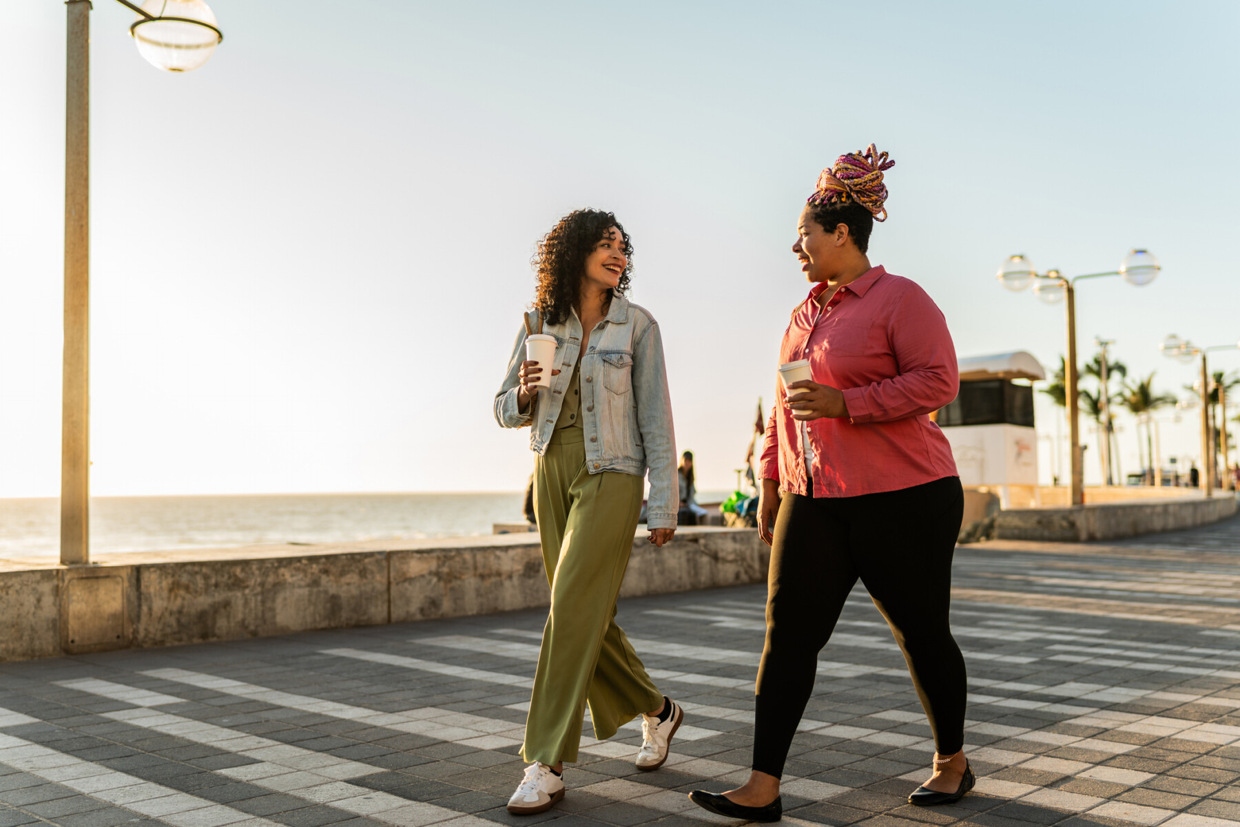 Two people walk on a boardwalk.