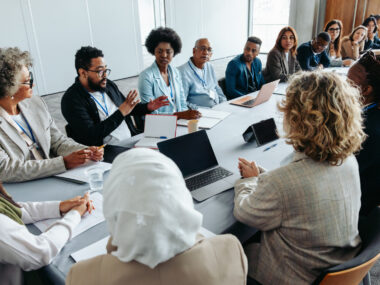 A group of people sit around a conference table.