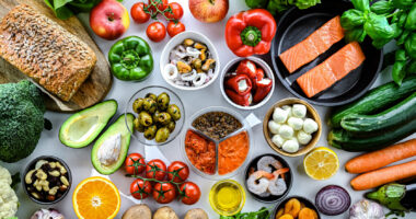 A variety of foods, primarily fruits and vegetables, are seen on a table.