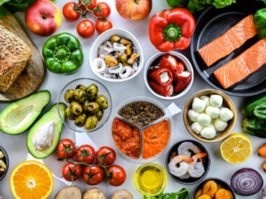 A variety of foods, primarily fruits and vegetables, are seen on a table.