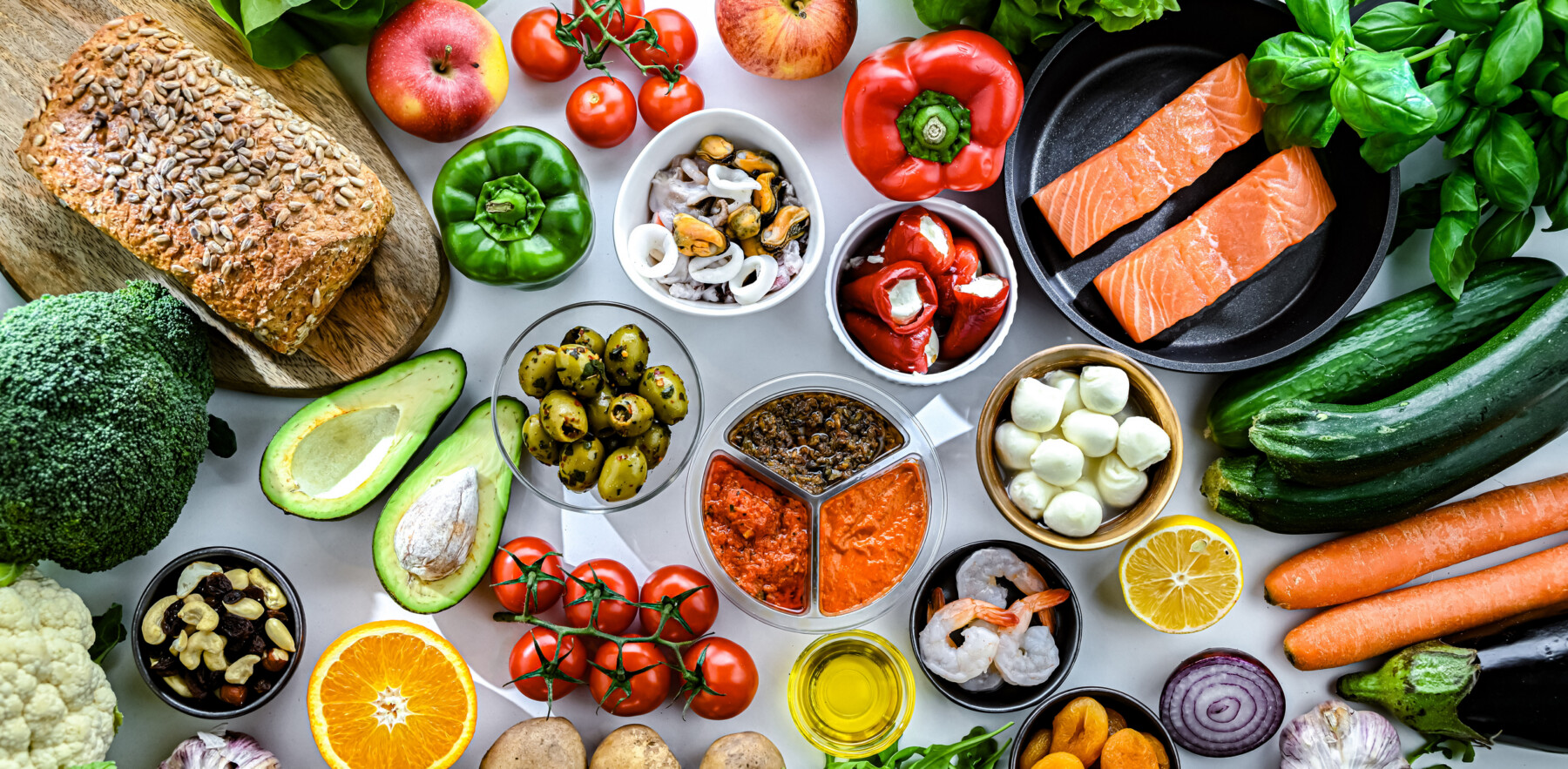 A variety of foods, primarily fruits and vegetables, are seen on a table.