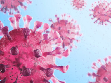 A close-up view shows the coronavirus in pink against a blue background.