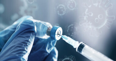 A syringe is shown drawing medication out of a small bottle.