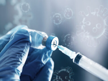 A syringe is shown drawing medication out of a small bottle.