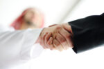 Two hands are shown shaking in agreement.