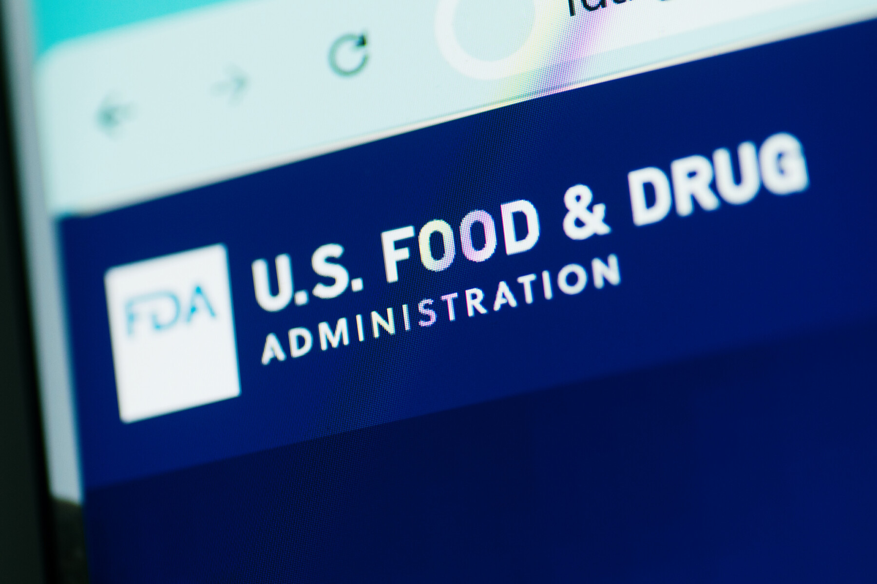 A close-up view of the U.S. Food and Drug Administration website shows the agency's name in white letters against a blue background.