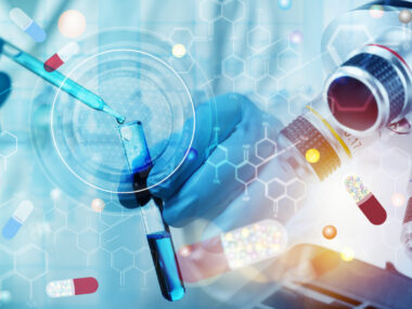 A researcher with blue-goved hands uses a dropper to add a liquid to a vial.
