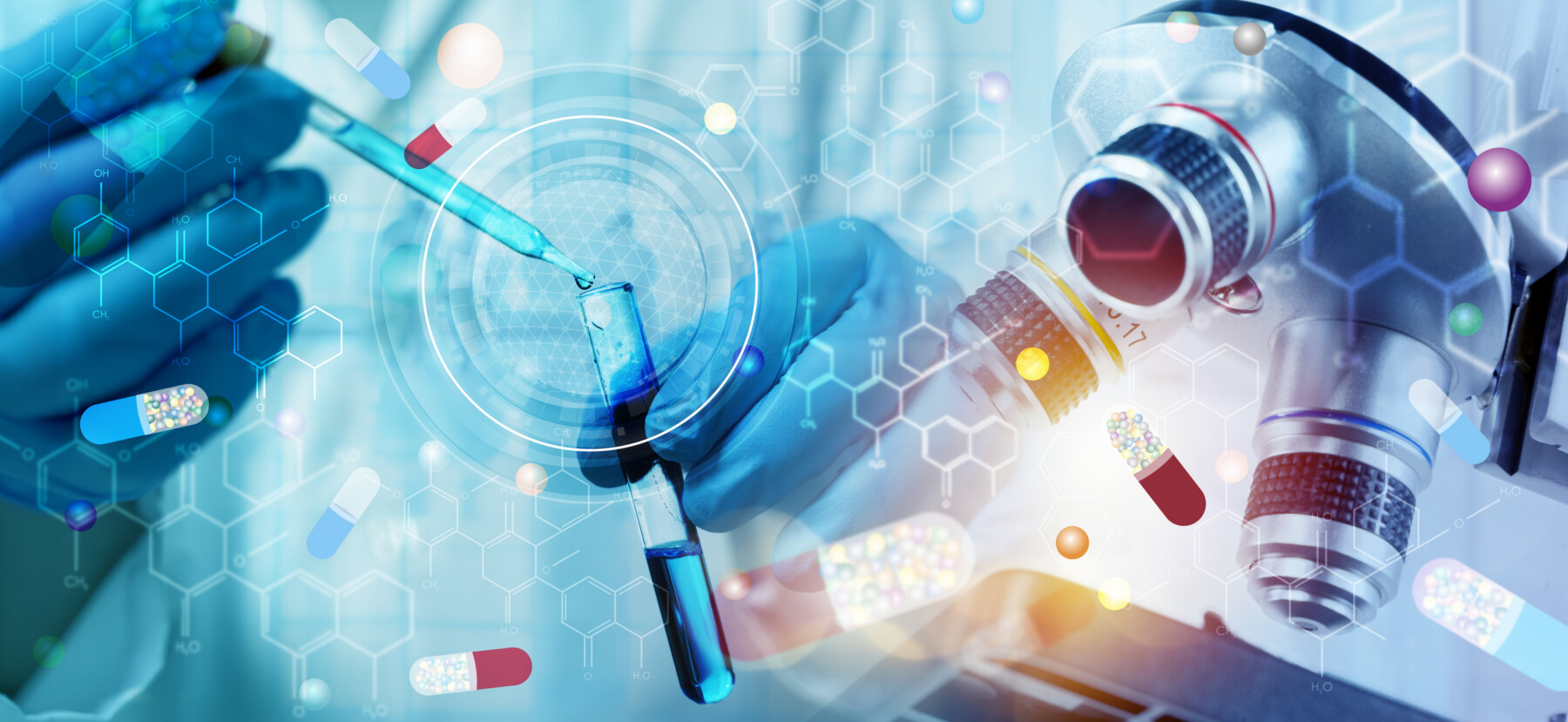 A researcher with blue-goved hands uses a dropper to add a liquid to a vial.