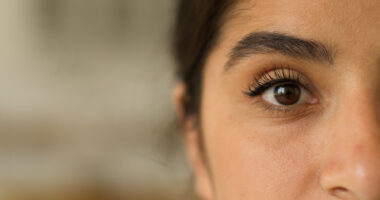 A close-up of a woman's face highlights one of her eyes.