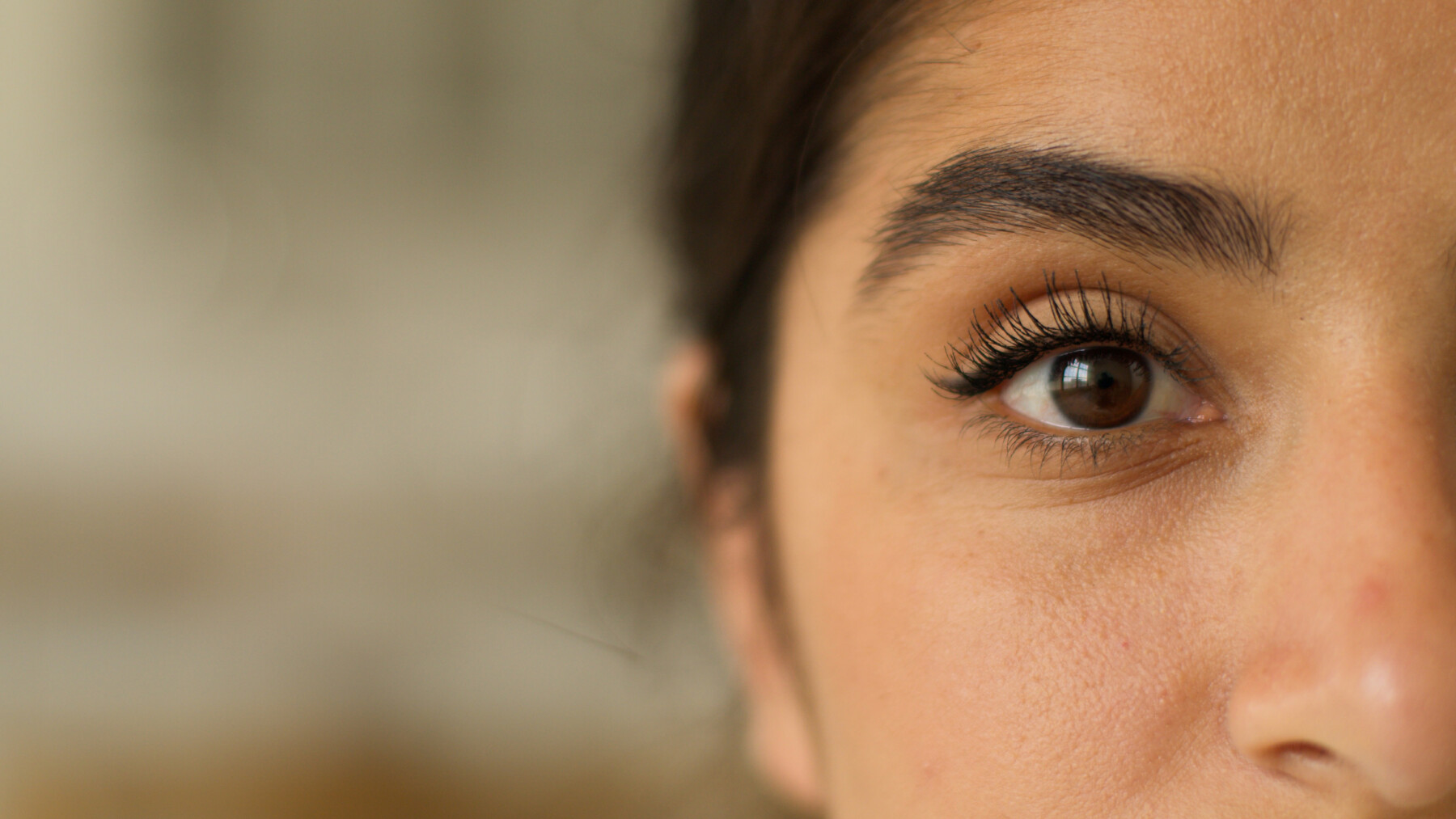 A close-up of a woman's face highlights one of her eyes.